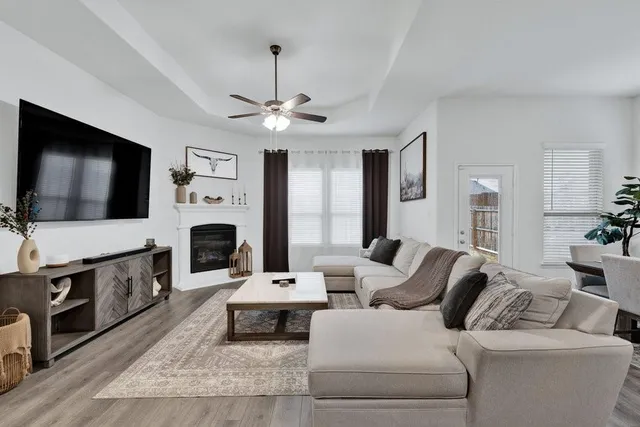 a living room with furniture a flat screen tv and a fireplace