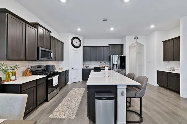 a large kitchen with a table and chairs