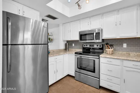a kitchen with white cabinets appliances and a sink