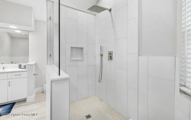 a bathroom with a shower a sink and a mirror