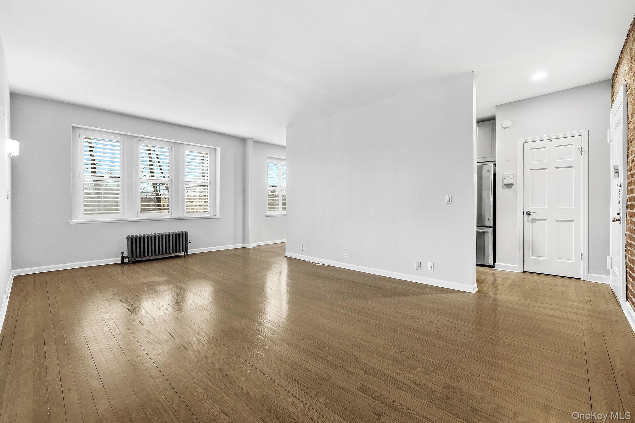 11 Alden Road, Unit 1M Larchmont, NY 10538 - Photo 6 of 25 an empty room with wooden floor and windows