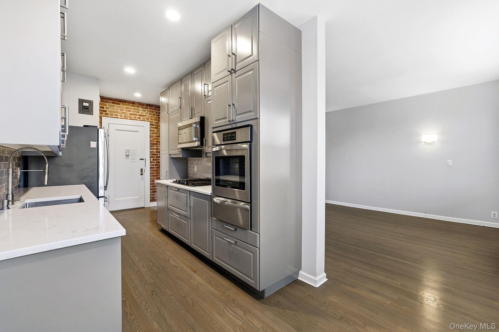 11 Alden Road, Unit 1M Larchmont, NY 10538 - Photo 9 of 25 a kitchen with stainless steel appliances a refrigerator a stove a sink and a oven