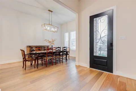 a dining room with furniture potted plants and wooden floor