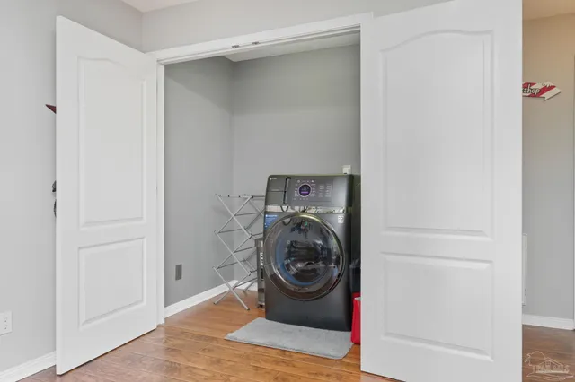 a view of a hallway with wooden floor and living room