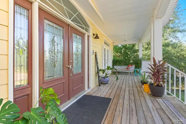 a balcony with couple of flower plants and wooden floor