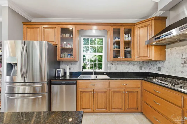 a kitchen with stainless steel appliances granite countertop a refrigerator a stove and a sink with wooden floor