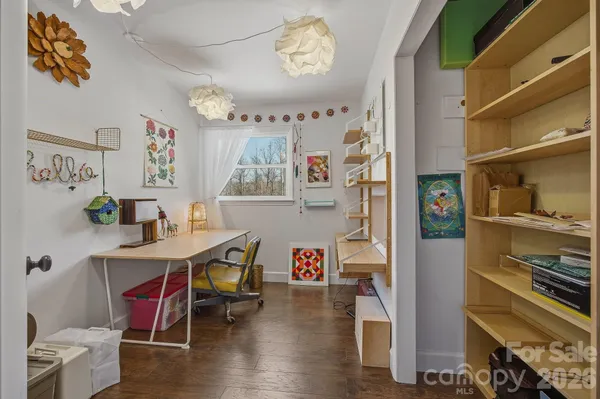 a living room with furniture and a dining table with wooden floor