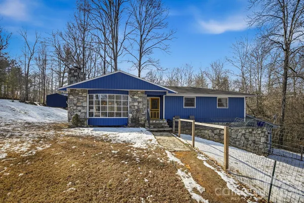 a view of a house with a yard covered in snow