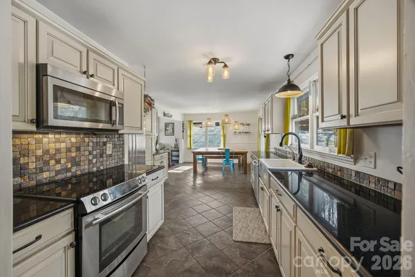 a kitchen with stainless steel appliances a sink a stove and cabinets
