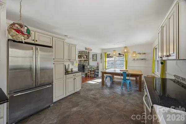 a kitchen with refrigerator and chairs