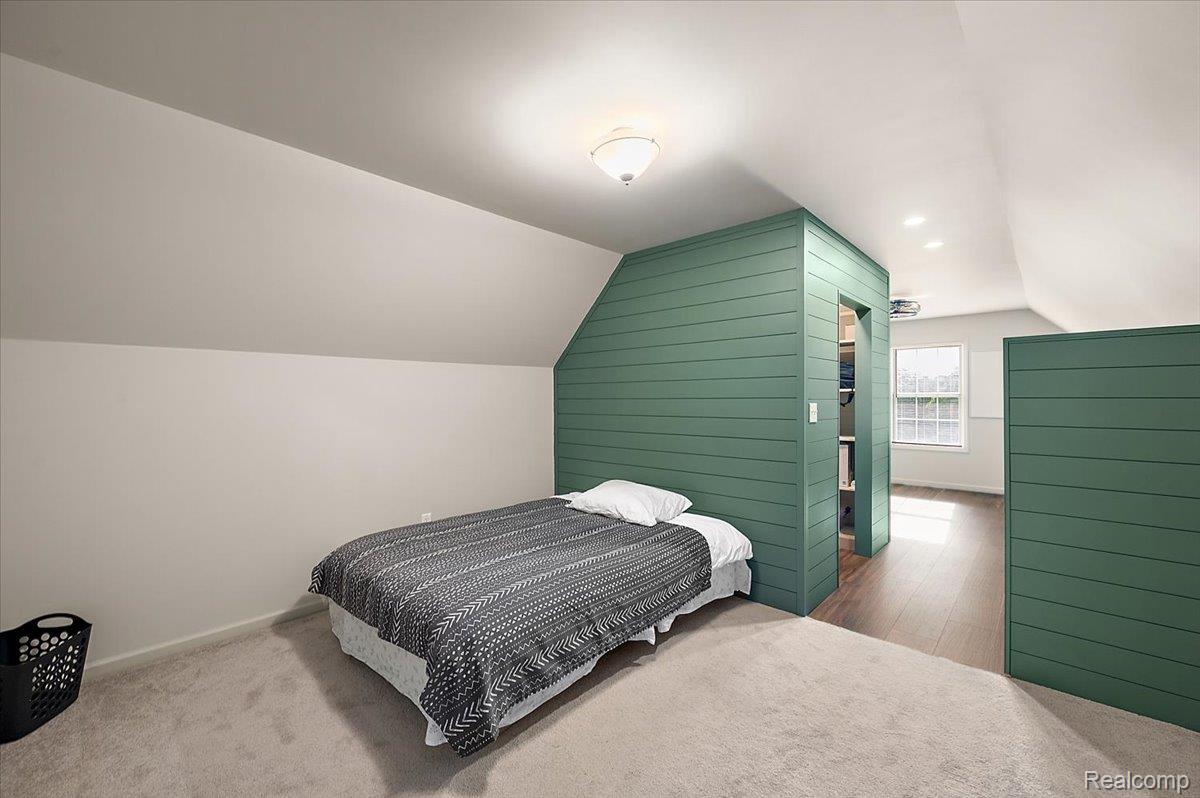 5035 Hidden Ridge Road Metamora, MI 48455 - Photo 36 of 62 Attic bedroom featuring angled ceilings, carpet flooring, and a central green shiplap accent wall