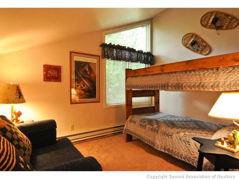 1977 Soda Ridge Road, Unit 1212 Keystone, CO 80435 - Photo 16 of 25 a bedroom with a bed and dresser with mirror