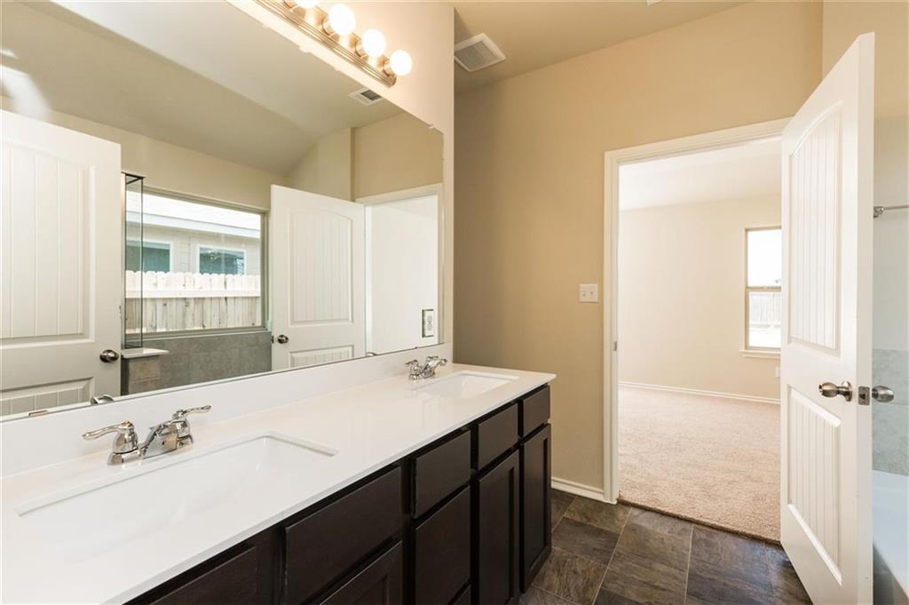 12912 Tinker Street Manor, TX 78653 - Photo 11 of 12 a bathroom with a sink a mirror and a vanity