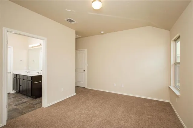 an empty room with kitchen view and a sink