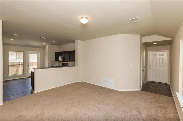 a view of a kitchen with a sink and dishwasher a refrigerator with wooden floor