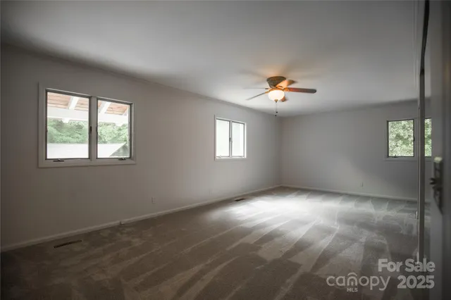 a view of empty room with fireplace and fan