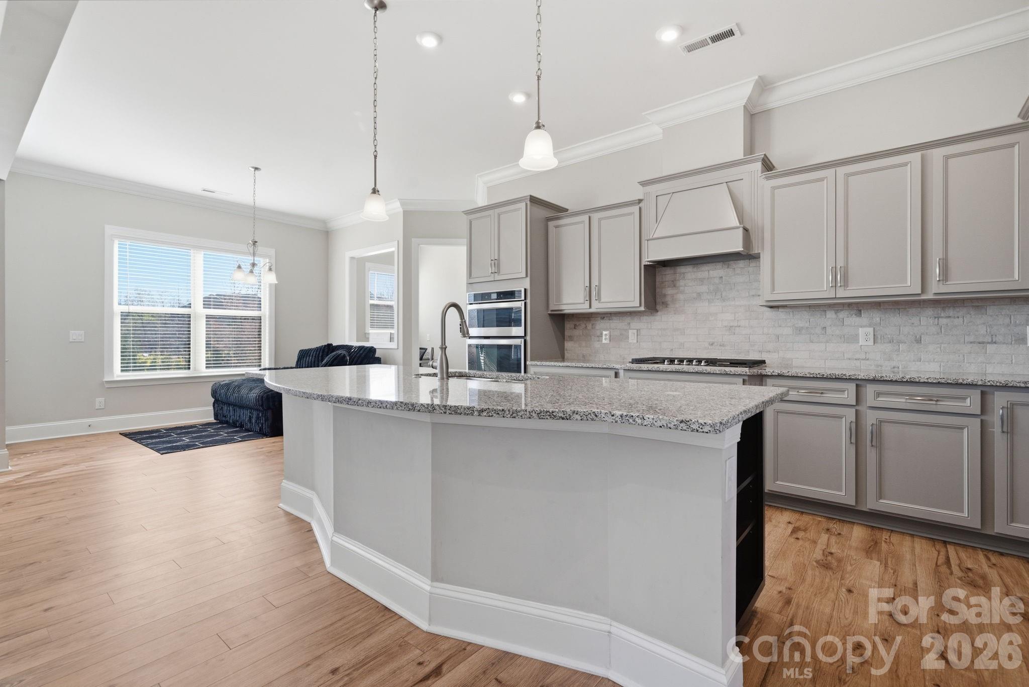 8920 Branch Brook Place Huntersville, NC 28078 - Photo 13 of 41 a kitchen with stainless steel appliances granite countertop a sink a stove and a wooden floors