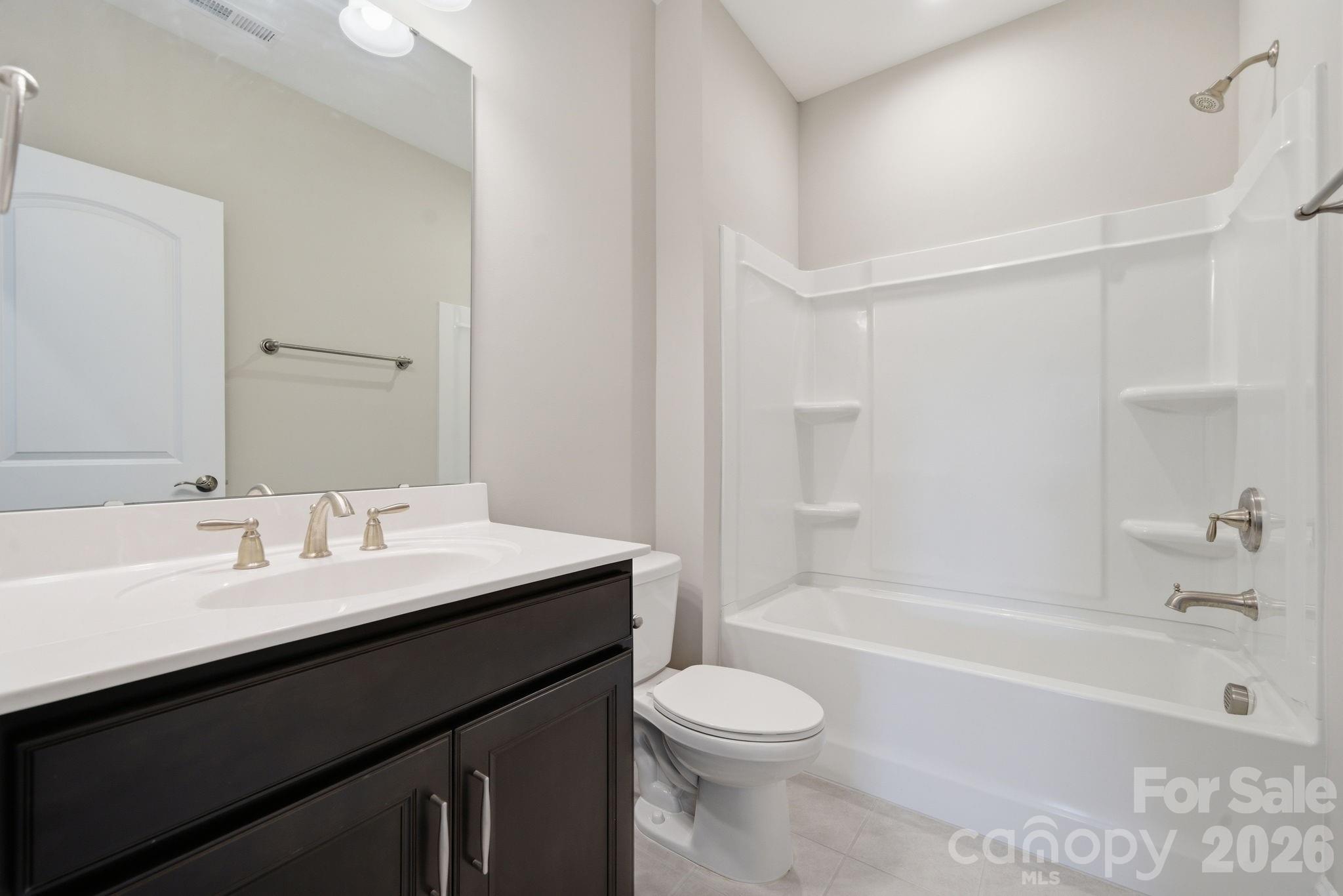 8920 Branch Brook Place Huntersville, NC 28078 - Photo 32 of 41 a bathroom with a bathtub a sink a toilet and a mirror