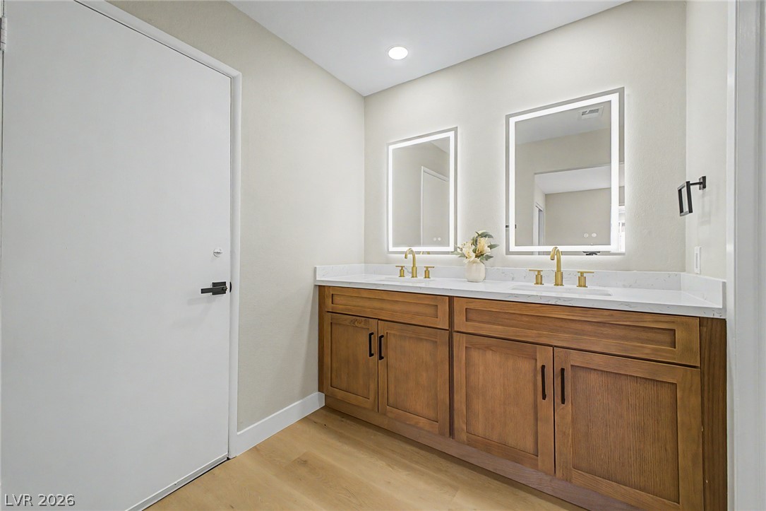 324 Lakehurst Road Las Vegas, NV 89145 - Photo 12 of 30 A wooden double vanity pairs with light wood flooring in this contemporary bathroom.