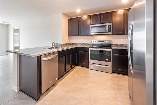 a view of a kitchen with a sink and a refrigerator