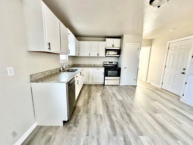 409 SW Avenue East Seminole, TX 79360 - Photo 7 of 16 a kitchen with stainless steel appliances granite countertop a refrigerator a stove and white cabinets with wooden floor