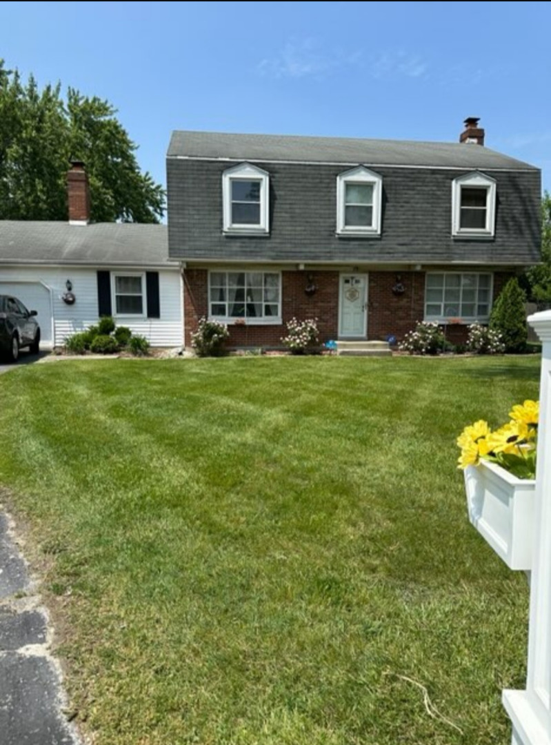 a view of house with a yard