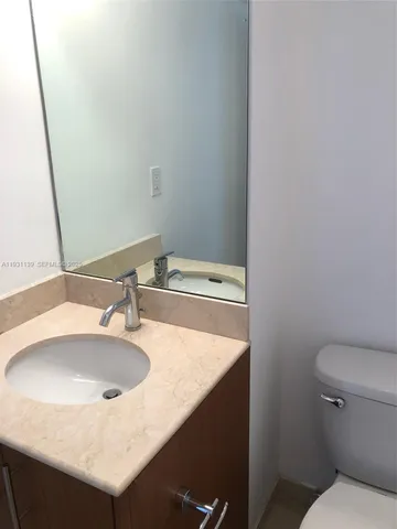 a bathroom with a granite countertop sink a toilet and shower