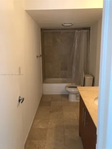 a bathroom with a granite countertop sink a toilet and bathtub