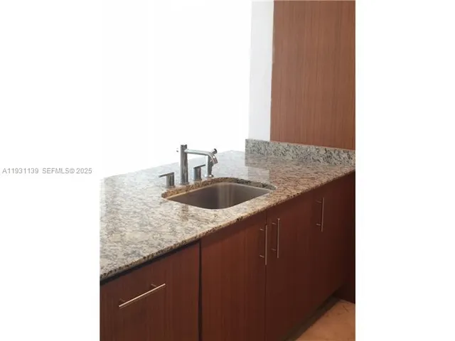 a bathroom with a granite countertop sink and vanity