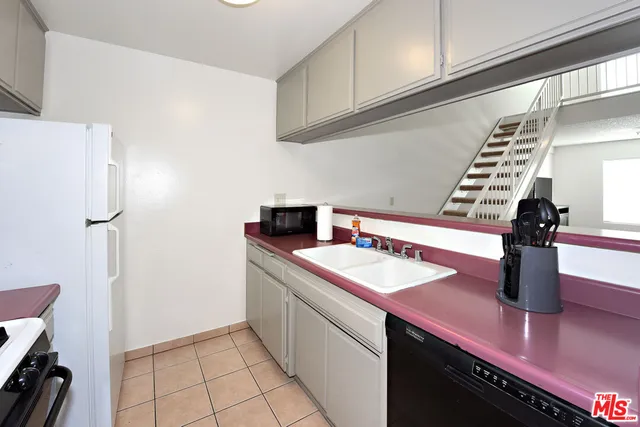 a kitchen with a sink a stove and a refrigerator