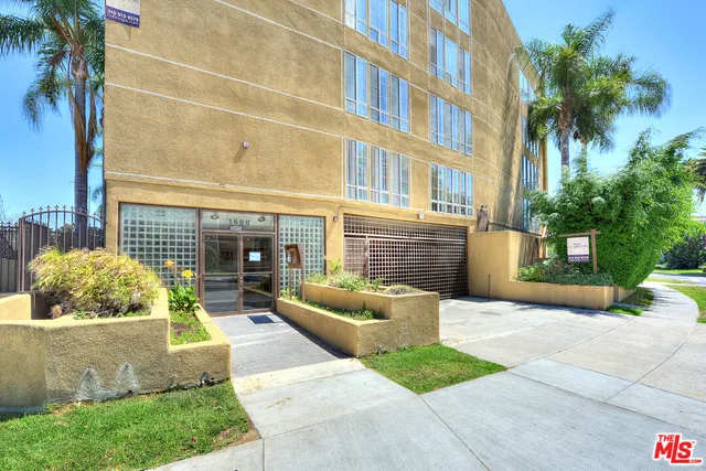 a front view of a house with outdoor seating and barbeque oven