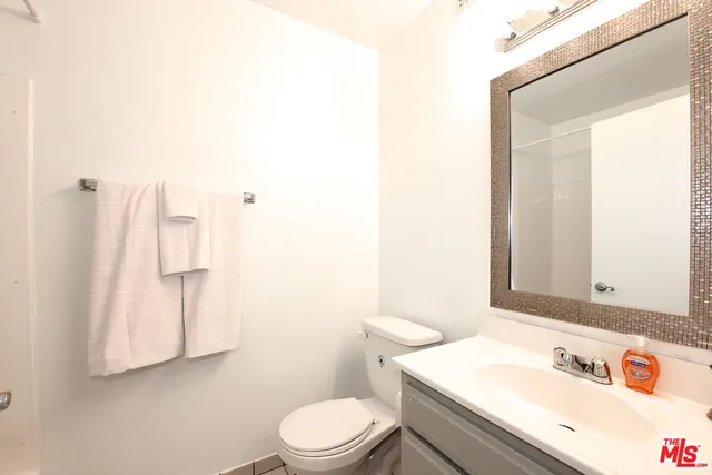 a bathroom with a sink vanity mirror and toilet