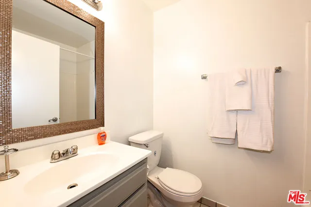 a bathroom with a sink a toilet and mirror