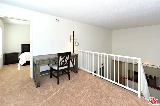 a view of a workspace with furniture and a window
