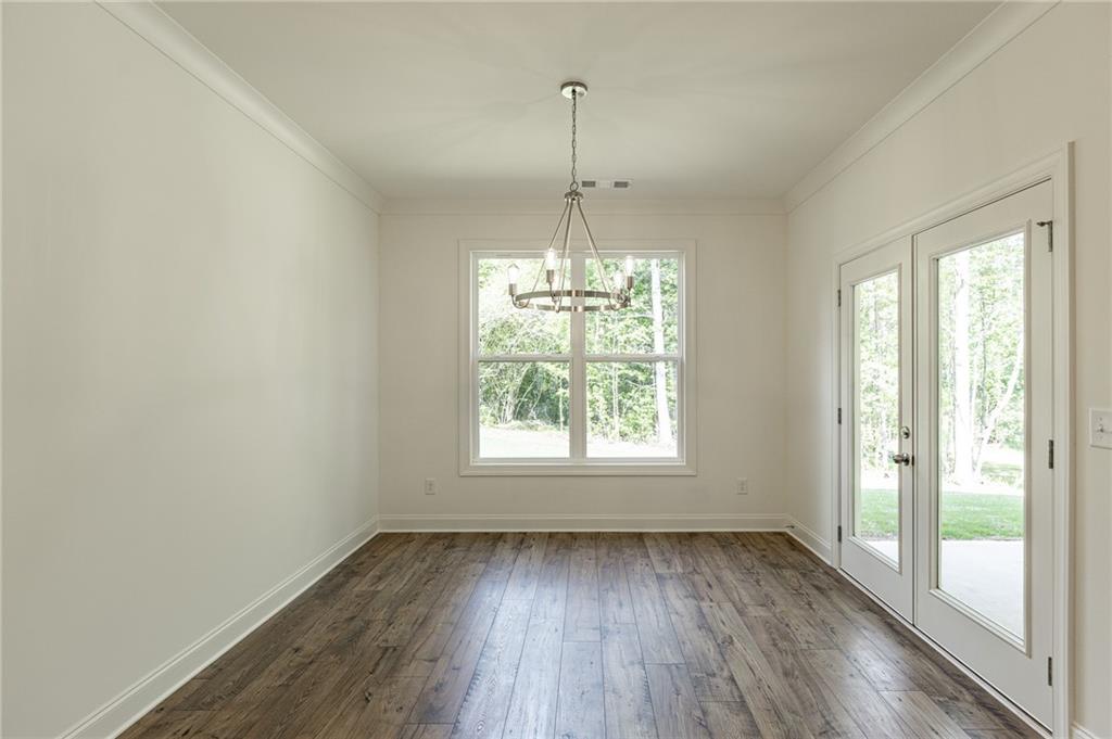 1210 Austin Road Winder, GA 30680 - Photo 19 of 56 an empty room with wooden floor and windows