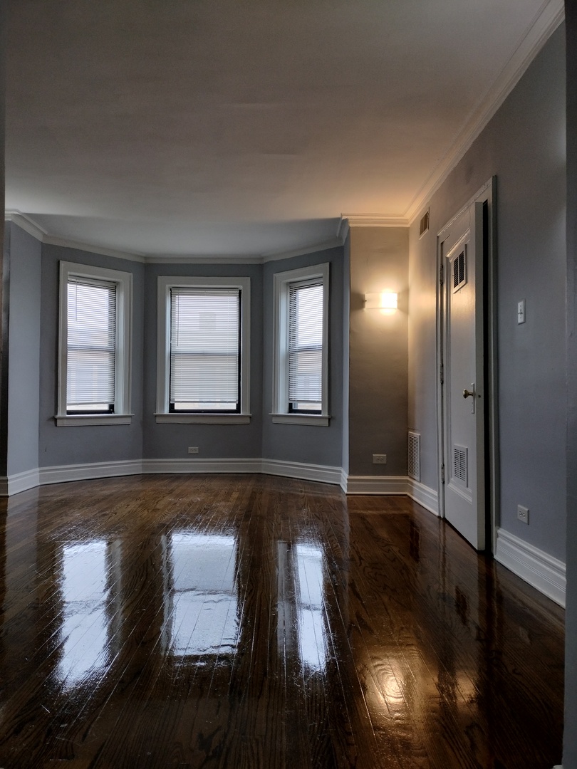 1739 West 80th Street, Unit 17933 Chicago, IL 60620 - Photo 5 of 17 a view of empty room with wooden floor and fan