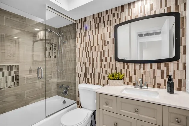 a bathroom with a sink a toilet and shower