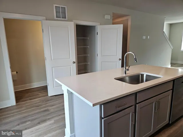 a kitchen with a sink cabinets and wooden floor
