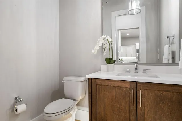 a bathroom with a granite countertop sink a toilet and a mirror