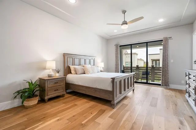 a bedroom with a bed table flowerpot and window
