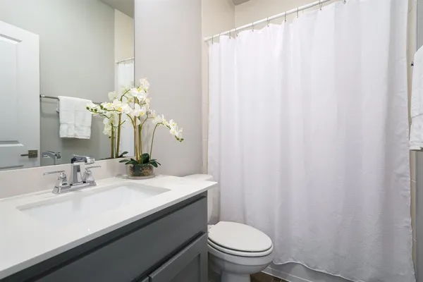 a bathroom with a sink a toilet and a mirror