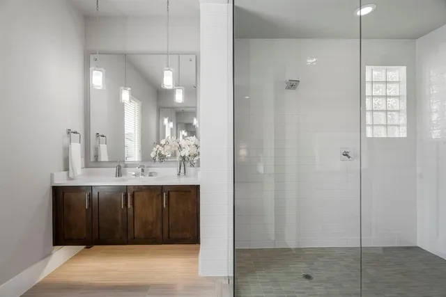 a bathroom with a sink shower and a mirror