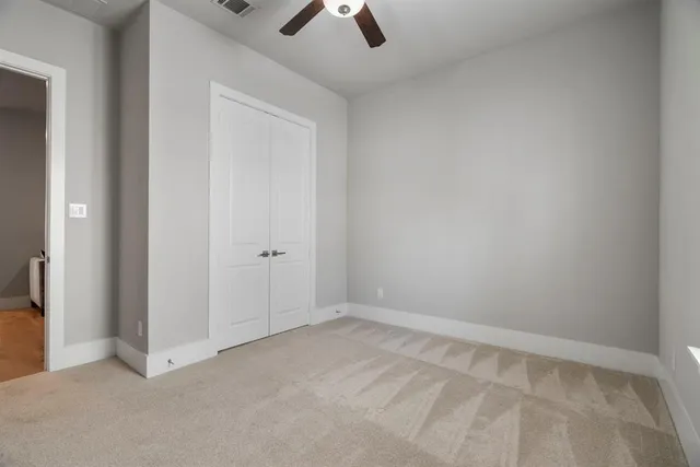 an empty room with chandelier fan