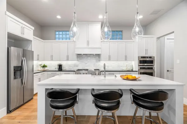 a kitchen with stainless steel appliances granite countertop a sink and a stove