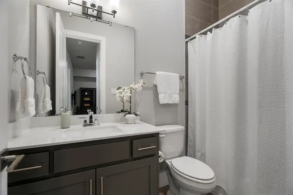 a bathroom with a sink a toilet and shower