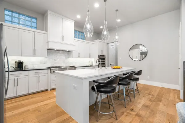 a kitchen with a dining table cabinets and appliances