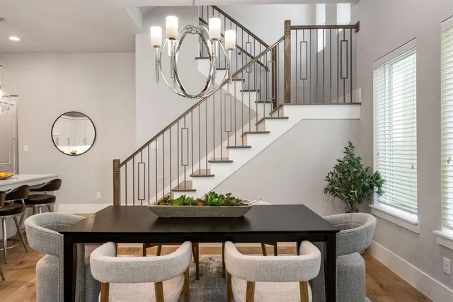 a view of a dining room with furniture a potted plant and wooden floor