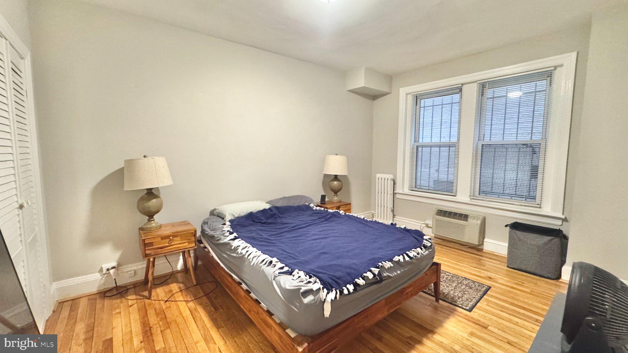 1954 Columbia Road Northwest, Unit 105 Washington, DC 20009 - Photo 7 of 12 a bed sitting in a bedroom next to a window