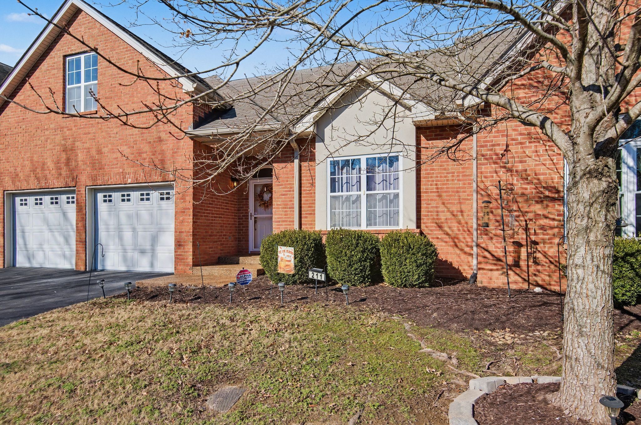 2521 Pennington Bend Road, Unit 211 Nashville, TN 37214 - Photo 1 of 21 a view of a brick house with large windows and a tree