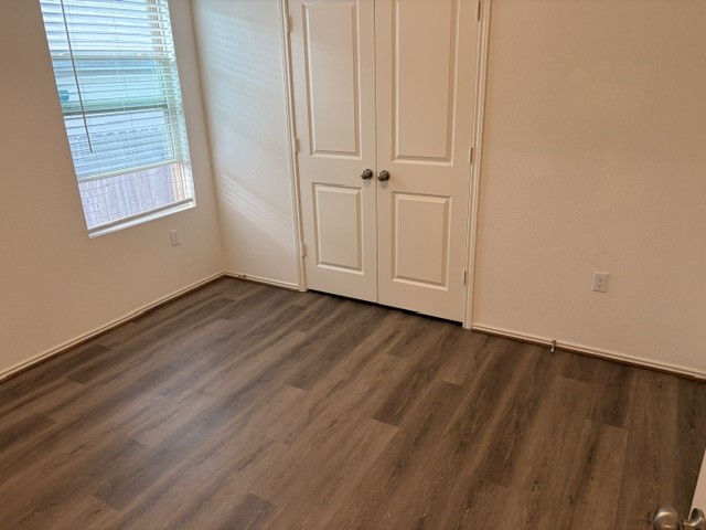 6917 Colorado Bluffs Road Austin, TX 78744 - Photo 11 of 19 an empty room with wooden floor and windows